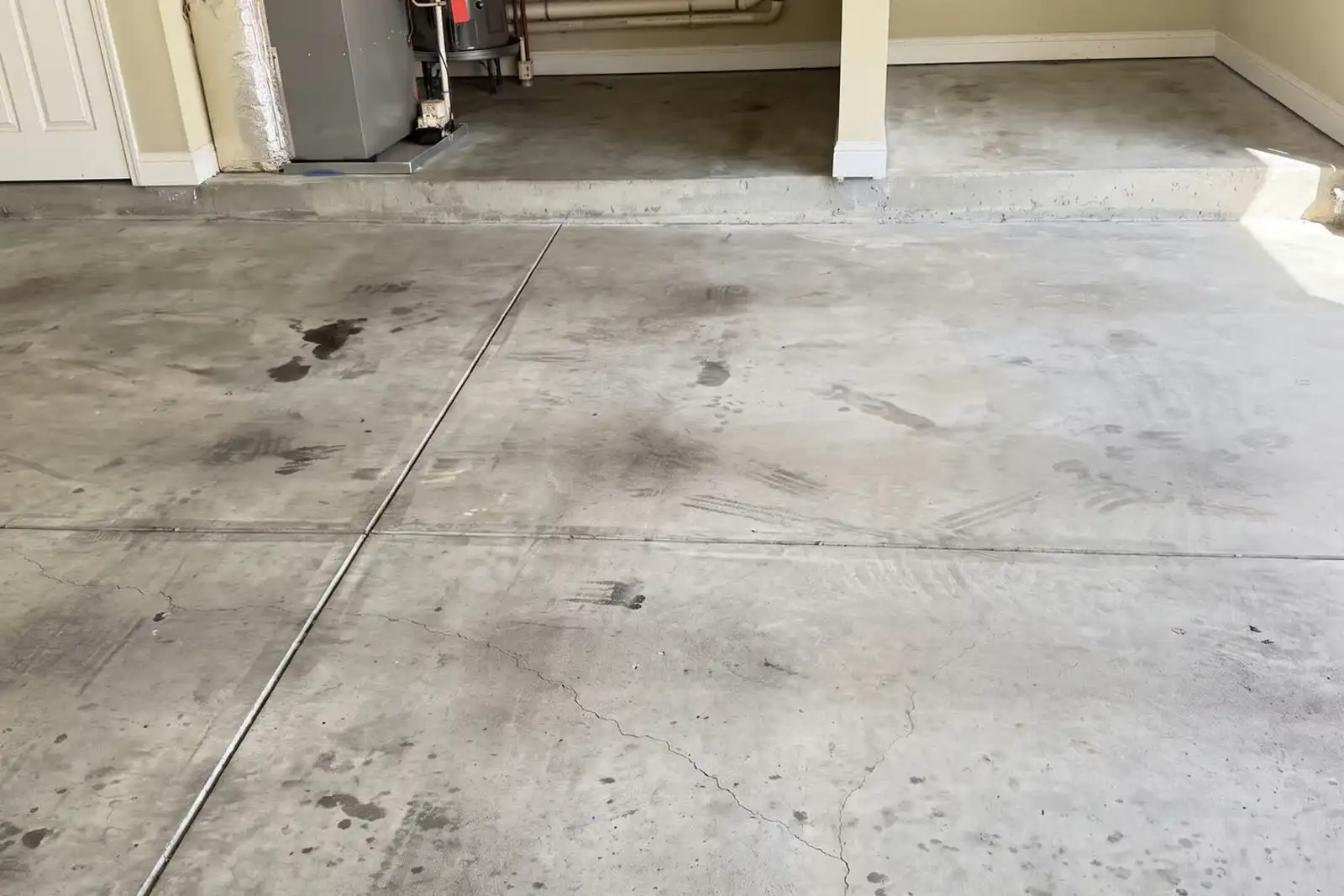 The same garage before: stained bare concrete